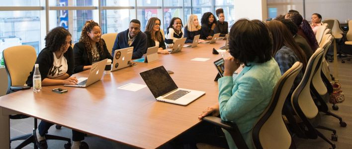 A diverse team of business professionals collaborating in a modern meeting room.