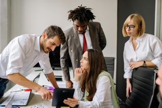 A group of professionals engaging in a collaborative business meeting in a modern office.